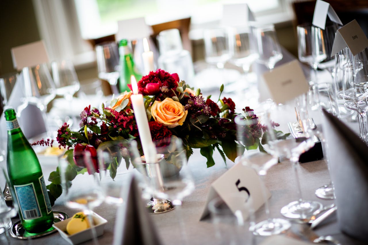 A beautifully arranged wedding table with flowers, candles, and elegant tableware.